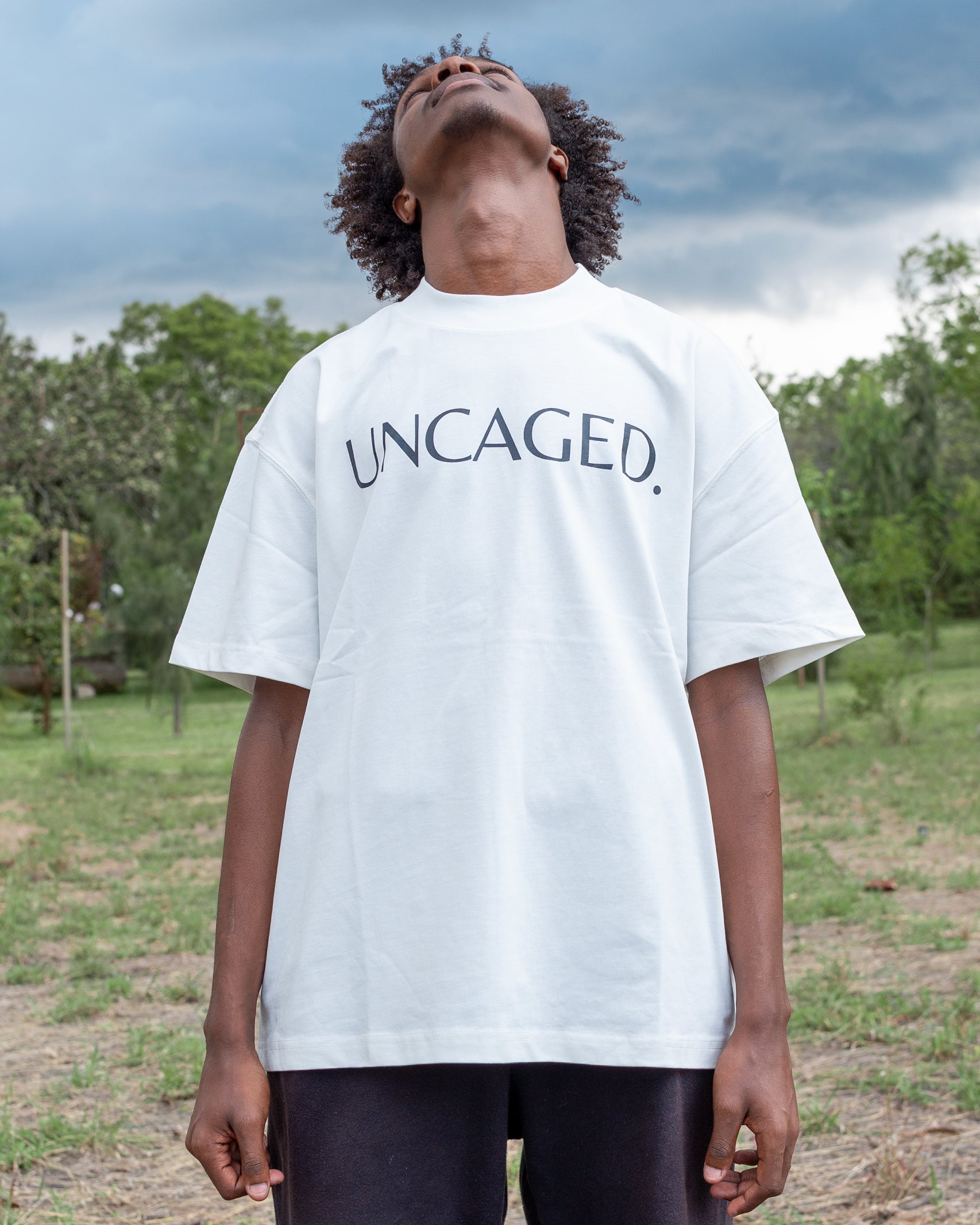 UNCAGED. Origin Tee in off-white — heavyweight oversized fit with tonal logo print.