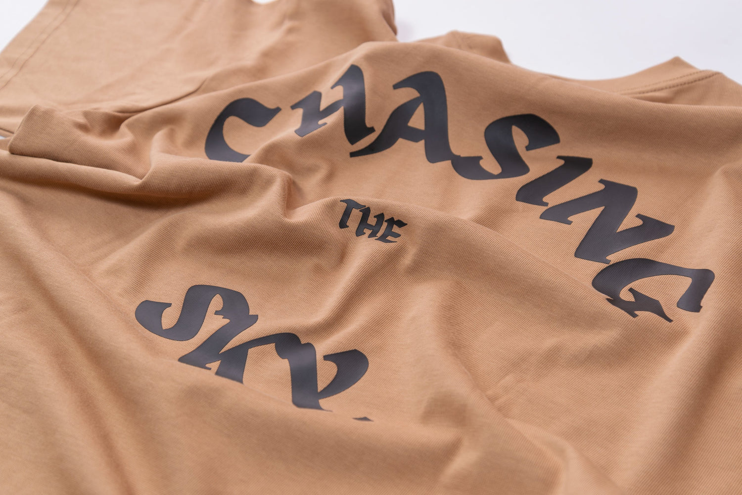 Back print of UNCAGED. ‘Chasing the Sky’ graphic on premium streetwear t-shirt
